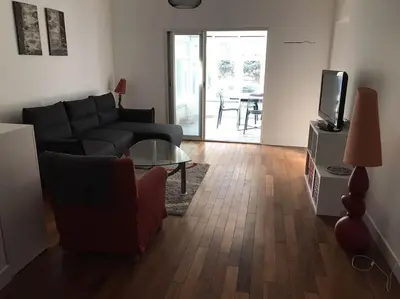 a living room with a couch and a tv and a table at Appartement au cœur de Cannes in Cannes