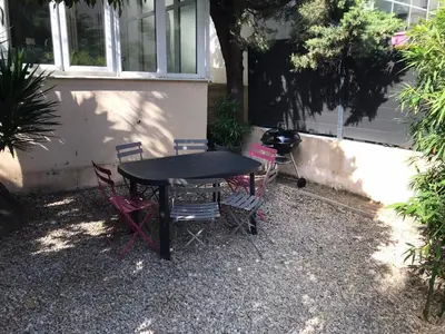 a black table and chairs in front of a house at Appartement au cœur de Cannes in Cannes