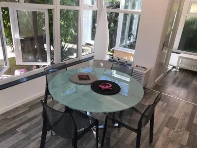 a glass table with chairs and a hat on it at Appartement au cœur de Cannes in Cannes