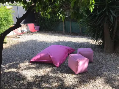 a pink pillow sitting on the ground next to two chairs at Appartement au cœur de Cannes in Cannes