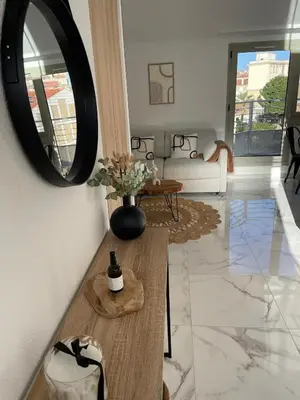 a living room with a table and a mirror at Duplex en bord de mer avec piscine et parking in Cannes