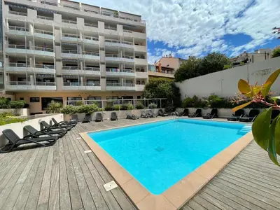 a swimming pool in front of a building at Duplex en bord de mer avec piscine et parking in Cannes