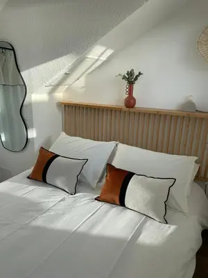 a white bed with two pillows on top of it at Duplex en bord de mer avec piscine et parking in Cannes