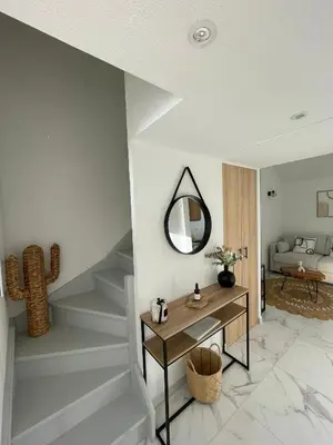 a living room with a table and a mirror at Duplex en bord de mer avec piscine et parking in Cannes