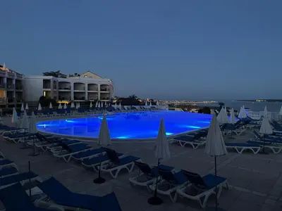a large swimming pool with chairs and umbrellas at Résidence de charme avec piscine à débordement in Cannes