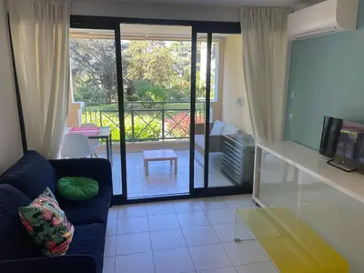 a living room with a couch and a sliding glass door at Résidence de charme avec piscine à débordement in Cannes