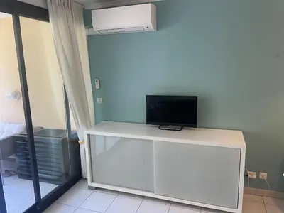 a living room with a blue couch and a table at Résidence de charme avec piscine à débordement in Cannes
