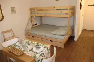 a room with a table and a bunk bed at Confort-Appartement cocooning *** in Le Cannet