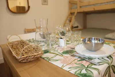 a table with glasses and plates and a basket on it at Confort-Appartement cocooning *** in Le Cannet