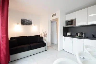 a living room with a couch and a kitchen at Stylish 2 rooms in the heart of Cannes in Cannes