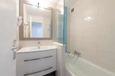 a white bathroom with a sink and a mirror at Stylish 2 rooms in the heart of Cannes in Cannes