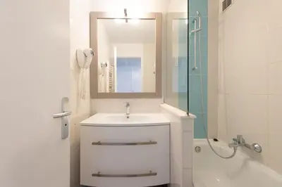 a white bathroom with a sink and a shower at Stylish 2 rooms in the heart of Cannes in Cannes