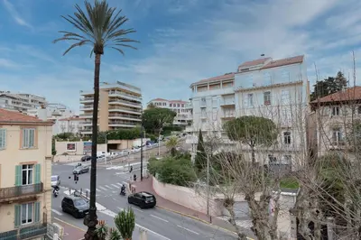 a city street with a palm tree and buildings at Stylish 2 rooms in the heart of Cannes in Cannes