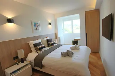 a bedroom with a large white bed with two pillows at COMPLETELY RENOVATED APARTMENT ON BLD CROISETTE, 3 PARENTAL BEDROOMS in Cannes
