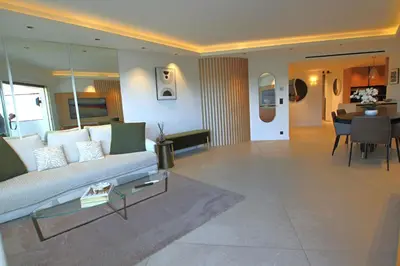 a living room with a couch and a dining room at COMPLETELY RENOVATED APARTMENT ON BLD CROISETTE, 3 PARENTAL BEDROOMS in Cannes