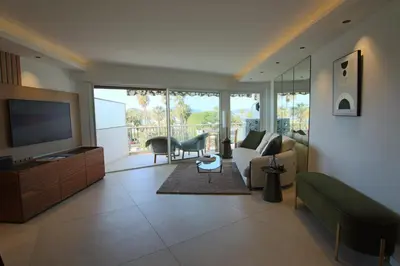a living room with a couch and a tv at COMPLETELY RENOVATED APARTMENT ON BLD CROISETTE, 3 PARENTAL BEDROOMS in Cannes