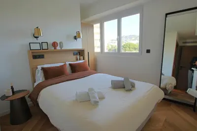 a bedroom with a large bed with towels on it at COMPLETELY RENOVATED APARTMENT ON BLD CROISETTE, 3 PARENTAL BEDROOMS in Cannes