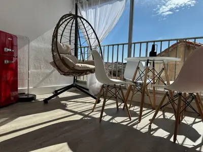 a balcony with a swing chair and a table at Toits du vieux port in Cannes