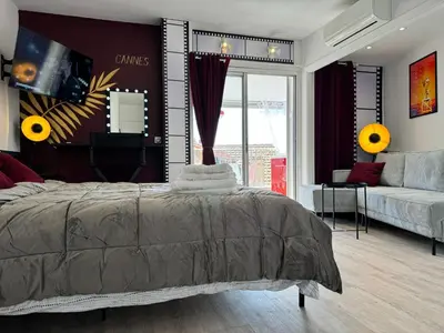 a bedroom with a bed and a large window at Toits du vieux port in Cannes
