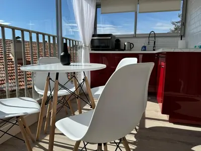 a balcony with a table and chairs and a kitchen at Toits du vieux port in Cannes