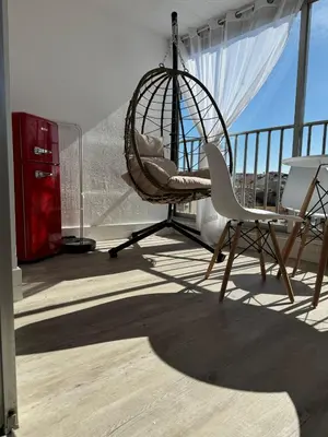 a room with a swing and two chairs on a balcony at Toits du vieux port in Cannes
