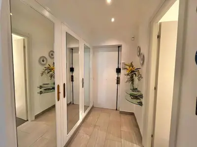 a hallway with mirrors and flowers on the walls at Le Colony in Cannes