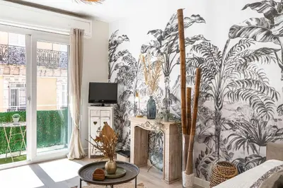 a living room with a mural of plants on the wall at Magnifique studio centre Cannes Vieux port-Croisette-Plages in Cannes