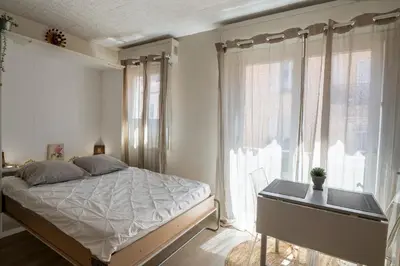 a bedroom with a bed and a desk and windows at Magnifique studio centre Cannes Vieux port-Croisette-Plages in Cannes