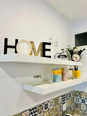 a kitchen with white cabinets and a clock on the wall at Luxury Studio à Cannes/Croisette in Cannes