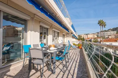 a table and chairs on the balcony of a building at 3-Br Apartment Terrace steps from Beaches in Cannes
