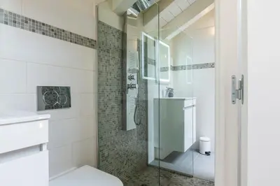 a bathroom with a glass shower and a toilet at Spacious Duplex in the Heart of Cannes in Cannes