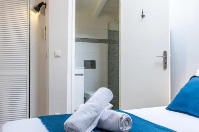 a bedroom with towels on a bed with a mirror at Spacious Duplex in the Heart of Cannes in Cannes