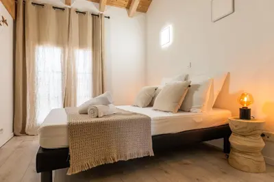 a bedroom with a bed with white sheets and a window at Spacious Duplex in the Heart of Cannes in Cannes