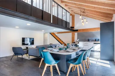 an open kitchen and dining room with a table and chairs at Spacious Duplex in the Heart of Cannes in Cannes