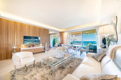 a living room with a white couch and a table at Somptuous 3 bedroom with sea-view on the Croisette in Cannes