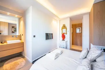 a bedroom with a white bed and a sink at Somptuous 3 bedroom with sea-view on the Croisette in Cannes