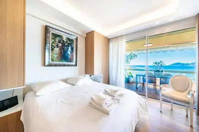 a bedroom with a white bed and a view of the ocean at Somptuous 3 bedroom with sea-view on the Croisette in Cannes