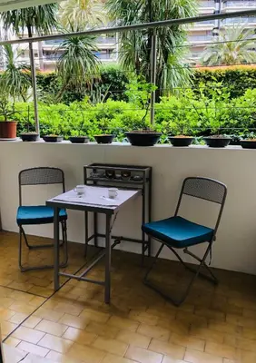 two chairs and a table in a room with plants at Studio Cannes Croisette in Cannes
