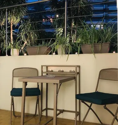 a table and two chairs with plants on a wall at Studio Cannes Croisette in Cannes