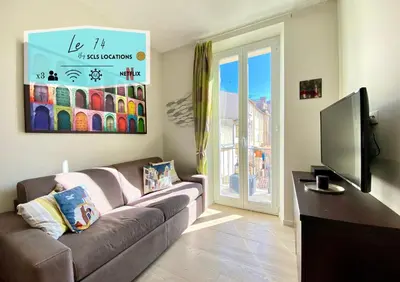 a living room with a couch and a flat screen tv at Le 74 By SCLS Locations in Cannes