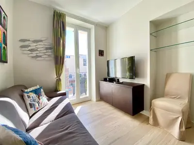 a living room with a couch and a flat screen tv at Le 74 By SCLS Locations in Cannes