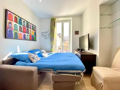 a bedroom with a blue bed and a chair at Le 74 By SCLS Locations in Cannes