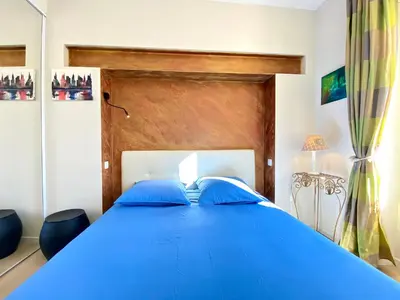 a blue bed with blue pillows in a bedroom at Le 74 By SCLS Locations in Cannes