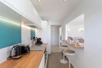 a kitchen with white walls and wooden counter tops at C7 - 1 BDR Pointe Croisette 5min Sea - Parking, AC & Terrace in Cannes