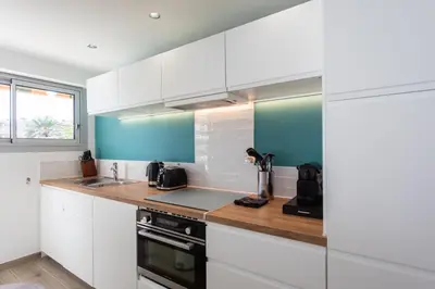 a kitchen with white cabinets and a counter top at C7 - 1 BDR Pointe Croisette 5min Sea - Parking, AC & Terrace in Cannes