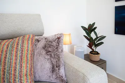 a couch with a pillow on a table with a lamp at C7 - 1 BDR Pointe Croisette 5min Sea - Parking, AC & Terrace in Cannes