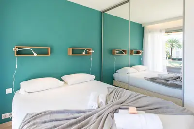 a bedroom with two beds and a mirror at C7 - 1 BDR Pointe Croisette 5min Sea - Parking, AC & Terrace in Cannes