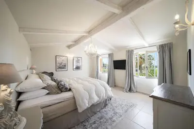 a white bedroom with a large bed with pillows at REF 2135 - Cannes - Villa for rent in Cannes