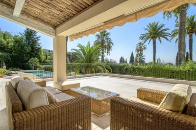 an outdoor patio with wicker chairs and a table at REF 2135 - Cannes - Villa for rent in Cannes