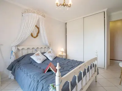 a bedroom with a large bed with a blue comforter at Apartment Les Cascades du Lac by Interhome in Le Cannet